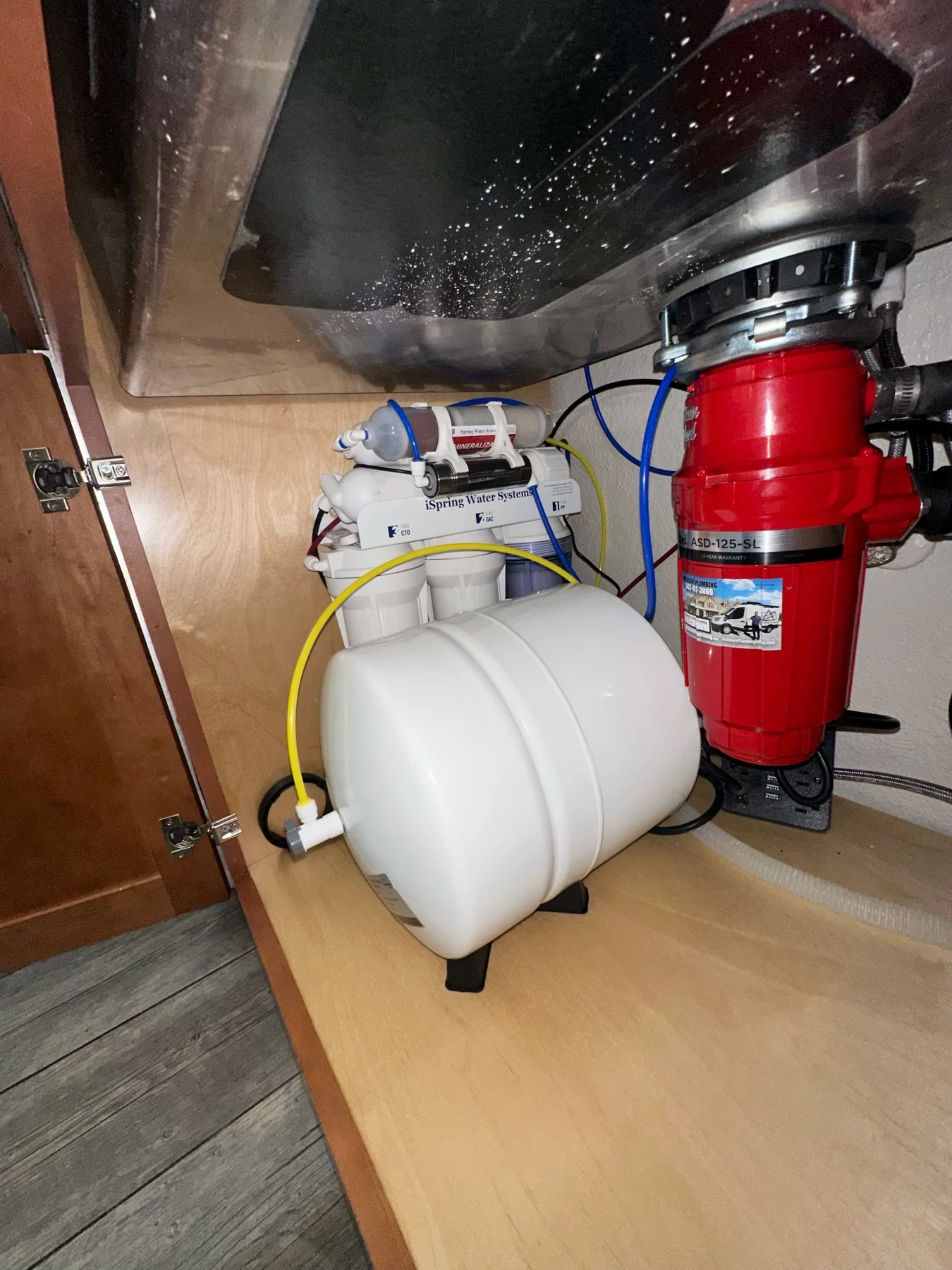 Red American Standard garbage disposal installed beneath a kitchen sink